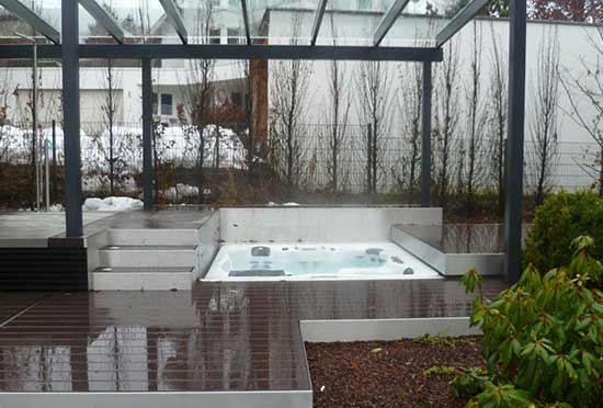 Hot tub recessed in wood deck with automated deck cover